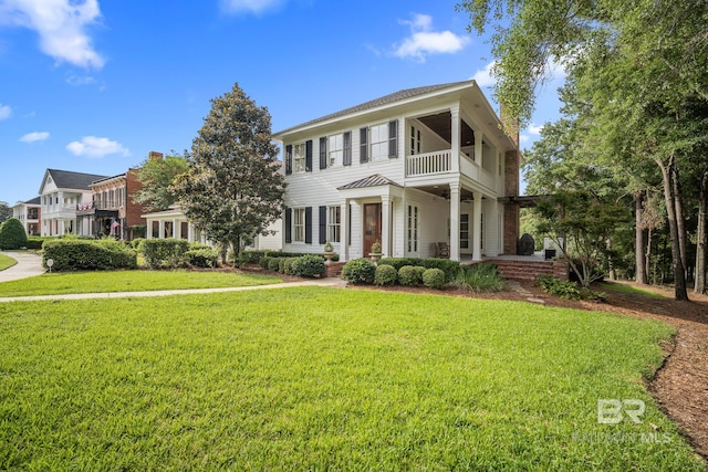 view of front of home featuring a front yard and a balcony