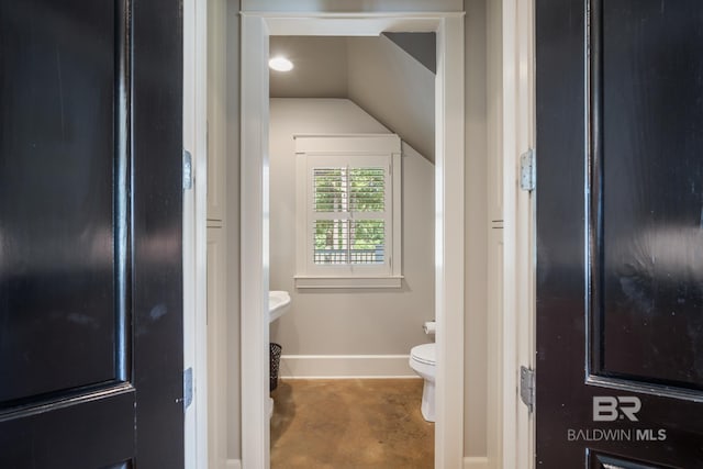 bathroom featuring vaulted ceiling and toilet