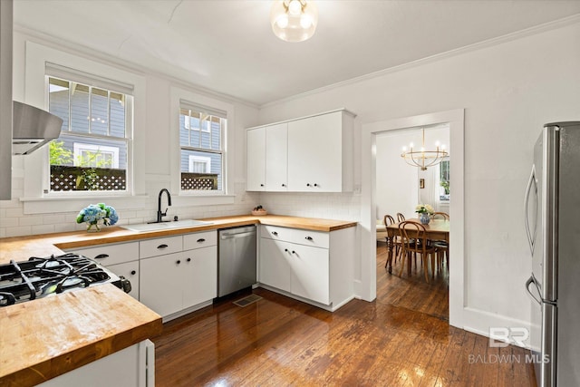 14 Macy Pl, Mobile, AL 36604 - kitchen with appliances with stainless steel finishes, wood counters, a chandelier, dark wood finished floors, and tasteful backsplash