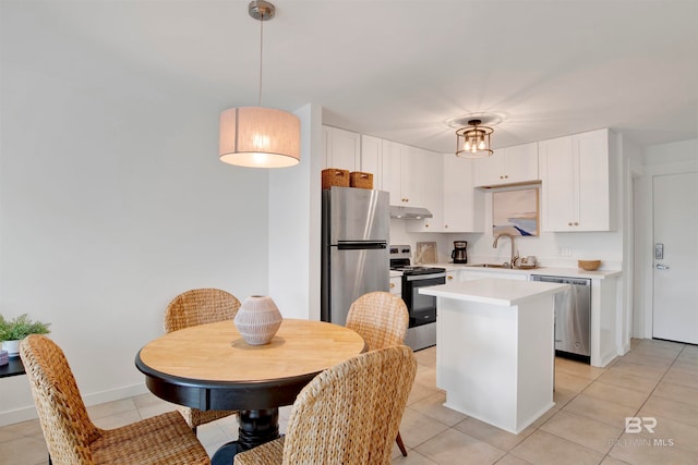 kitchen featuring a kitchen island, sink, pendant lighting, white cabinetry, and appliances with stainless steel finishes