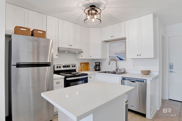 kitchen with sink, a kitchen island, stainless steel appliances, white cabinets, and light tile patterned floors