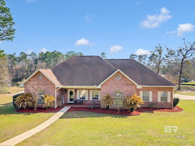 single story home with covered porch, brick siding, roof with shingles, and a front yard