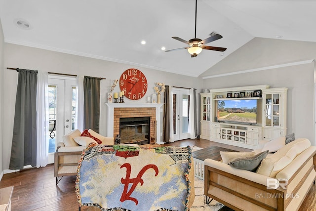 living area featuring a fireplace, vaulted ceiling, wood finished floors, and french doors