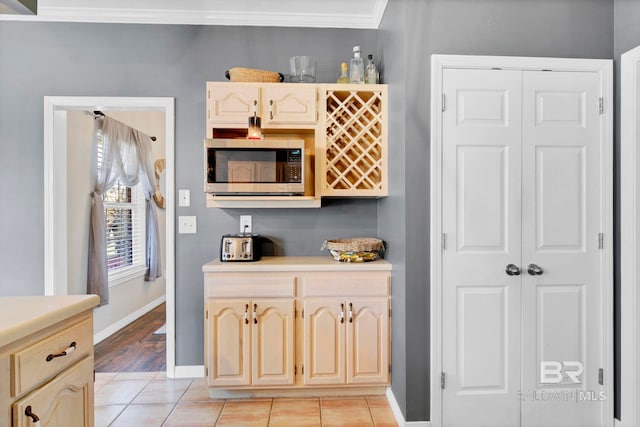 interior space with baseboards, stainless steel microwave, light countertops, and light tile patterned flooring