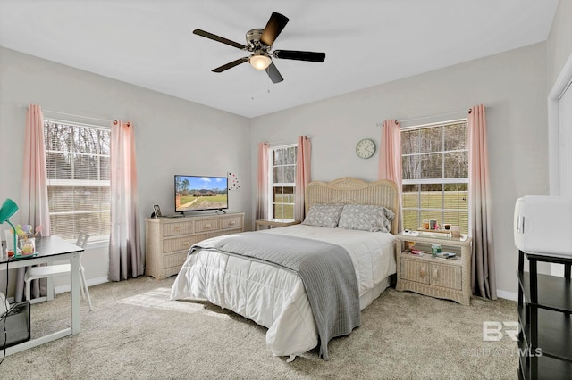 bedroom with light colored carpet, ceiling fan, and baseboards