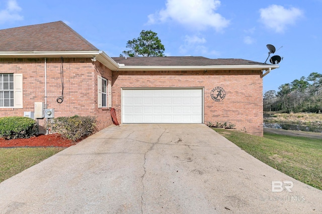 view of home's exterior with a garage, concrete driveway, brick siding, and roof with shingles