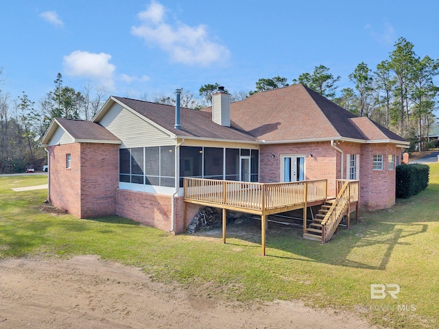 back of property with a sunroom, a yard, a chimney, and a wooden deck