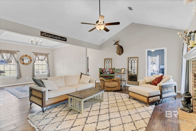 living area featuring ceiling fan with notable chandelier, ornamental molding, wood finished floors, and visible vents