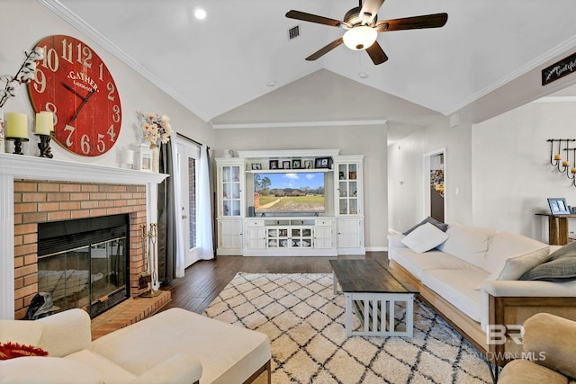 living room with lofted ceiling, visible vents, ornamental molding, a brick fireplace, and wood finished floors