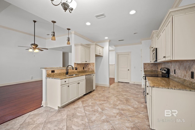 kitchen with sink, light stone counters, decorative backsplash, appliances with stainless steel finishes, and light wood-type flooring