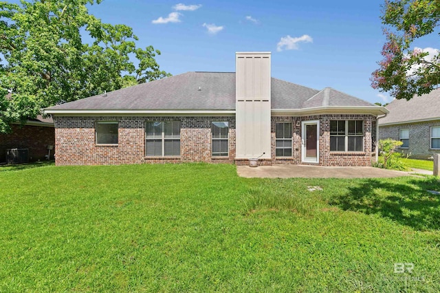 back of house featuring a lawn, cooling unit, and a patio area