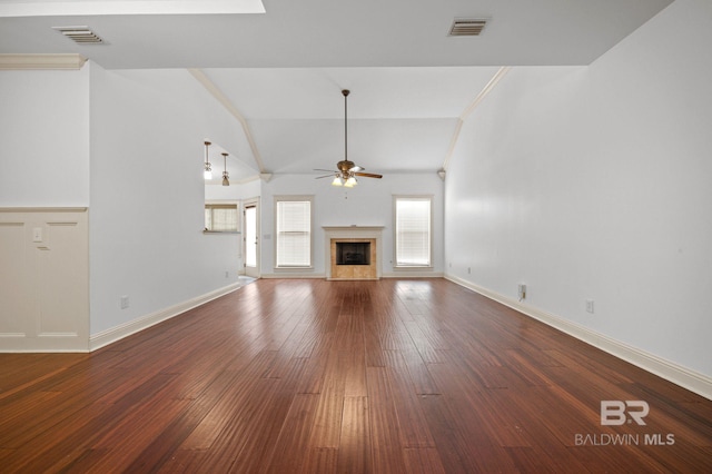 unfurnished living room with ceiling fan, dark wood-type flooring, vaulted ceiling, and ornamental molding