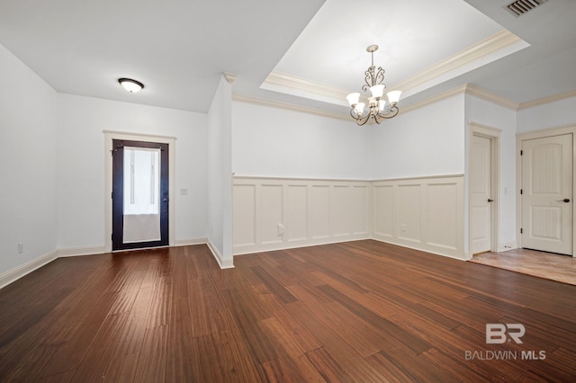 entrance foyer featuring a tray ceiling, dark hardwood / wood-style floors, and a notable chandelier