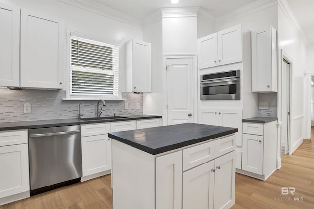 4340 Hamilton Oaks Ln, Mobile, AL 36695 - kitchen with appliances with stainless steel finishes, dark countertops, light wood-style flooring, decorative backsplash, and crown molding