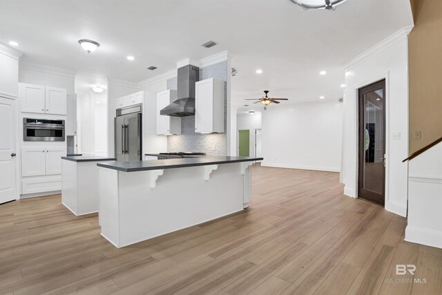 4340 Hamilton Oaks Ln, Mobile, AL 36695 - kitchen featuring wall chimney exhaust hood, appliances with stainless steel finishes, dark countertops, tasteful backsplash, and ceiling fan