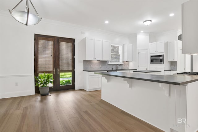 4340 Hamilton Oaks Ln, Mobile, AL 36695 - kitchen with dark countertops, a kitchen bar, french doors, decorative backsplash, and recessed lighting