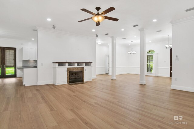 4340 Hamilton Oaks Ln, Mobile, AL 36695 - unfurnished living room with a chandelier, ornate columns, ceiling fan, a fireplace, and light wood finished floors