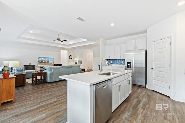 kitchen featuring stainless steel appliances, sink, a center island with sink, and white cabinets