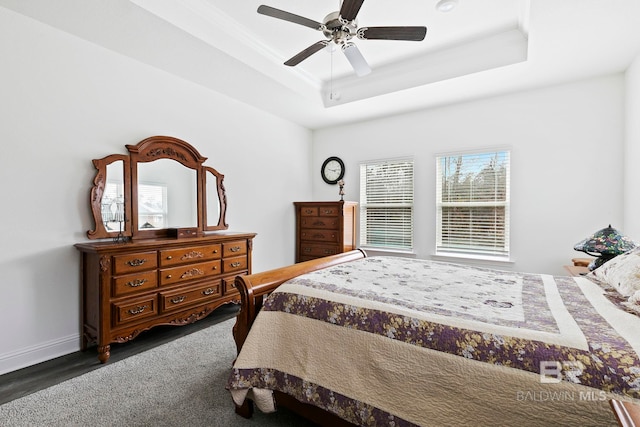 bedroom with ceiling fan and a raised ceiling