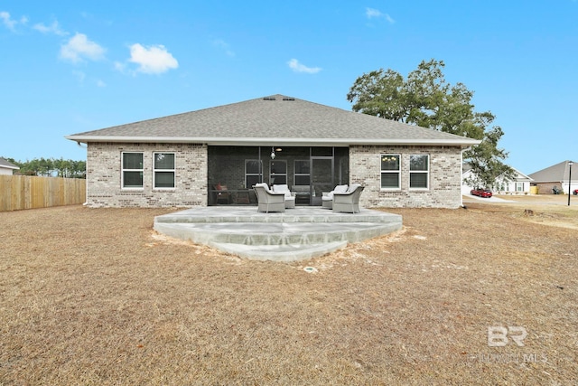 rear view of property featuring a sunroom and a patio area