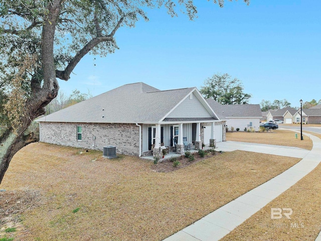 view of front of home featuring cooling unit, a porch, and a front yard