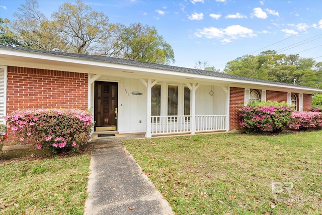 ranch-style house with brick siding, a porch, and a front lawn