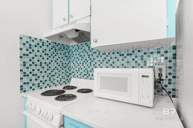 325 E 22nd Ave Unit 4, Gulf Shores, AL 36542 - kitchen featuring white appliances, light countertops, under cabinet range hood, white cabinetry, and tile walls