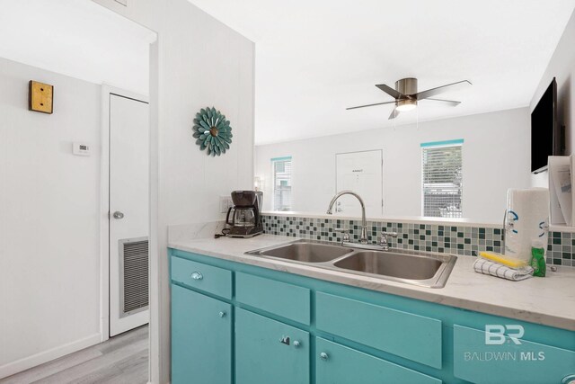 325 E 22nd Ave Unit 4, Gulf Shores, AL 36542 - kitchen featuring a sink, visible vents, light wood-type flooring, and decorative backsplash