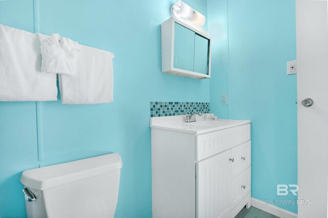325 E 22nd Ave Unit 4, Gulf Shores, AL 36542 - bathroom featuring baseboards, tasteful backsplash, toilet, and vanity