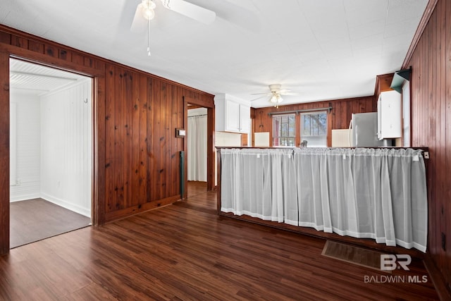 kitchen featuring ceiling fan, refrigerator, wood-type flooring, kitchen peninsula, and wood walls