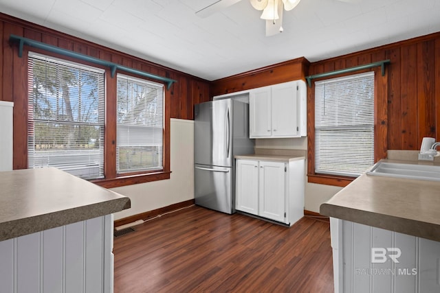 kitchen with sink, dark wood-type flooring, stainless steel refrigerator, ceiling fan, and white cabinets