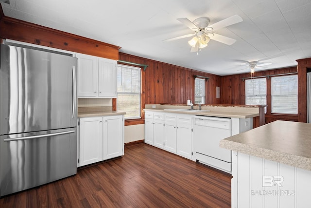 kitchen featuring white cabinetry, dishwasher, sink, and stainless steel fridge