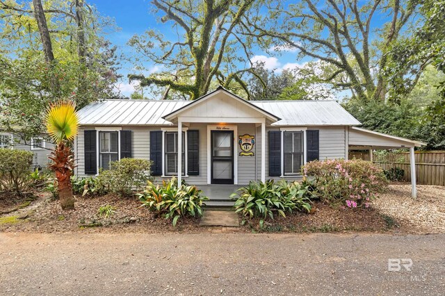 view of front of house with metal roof, fence, and a standing seam roof