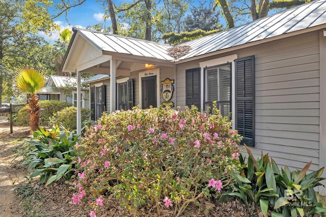 doorway to property featuring metal roof and a standing seam roof
