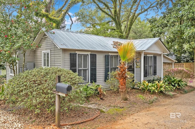 ranch-style house with fence and metal roof