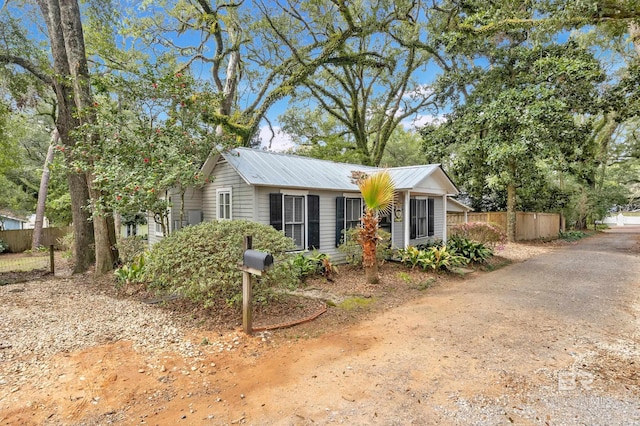 single story home with fence and metal roof