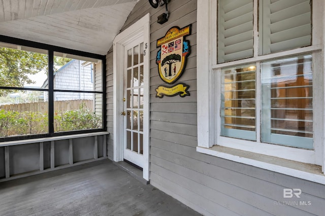 unfurnished sunroom featuring vaulted ceiling