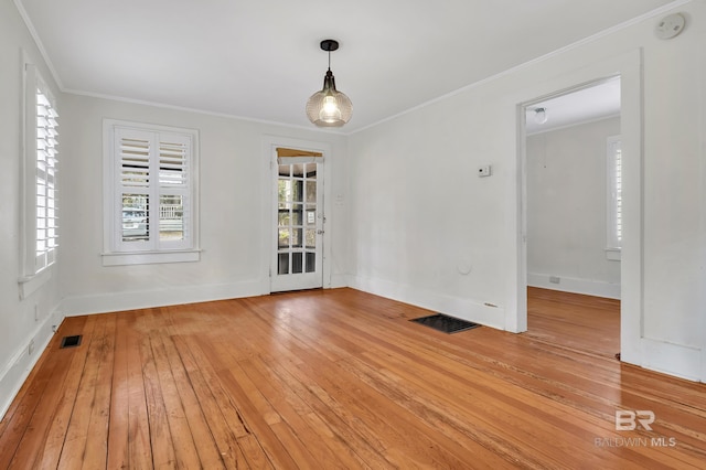 unfurnished room with visible vents, baseboards, light wood-style flooring, and crown molding