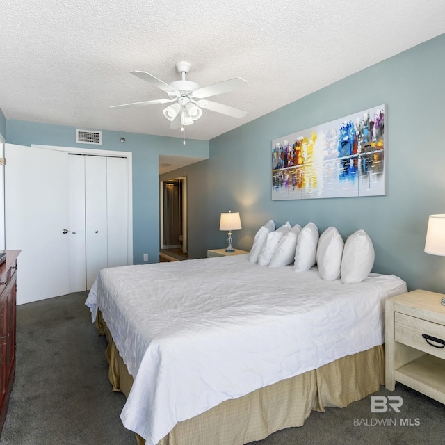 bedroom featuring visible vents, a textured ceiling, a closet, carpet flooring, and ceiling fan