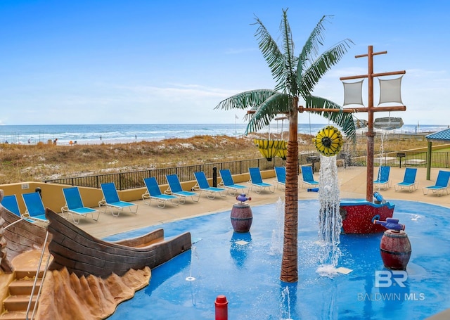 view of swimming pool featuring a patio, fence, and a water view