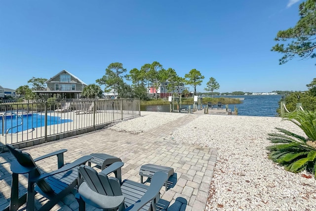 view of patio / terrace with a water view and a fenced in pool