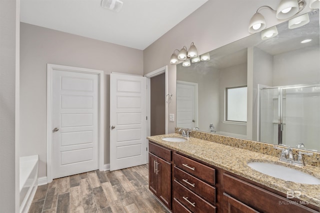 bathroom featuring vanity, wood-type flooring, and shower with separate bathtub