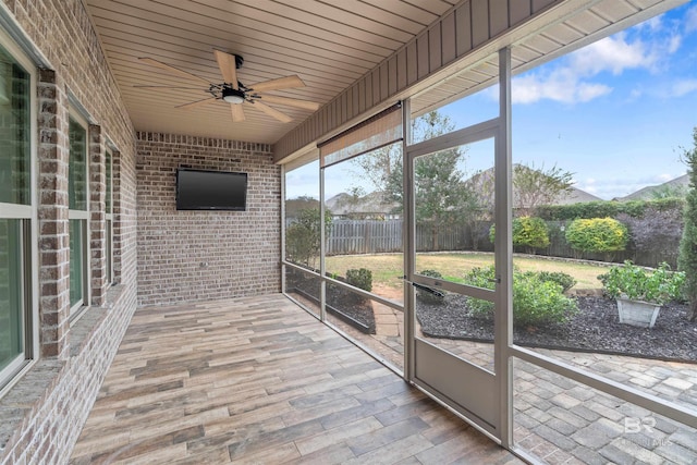 unfurnished sunroom with ceiling fan and wood ceiling