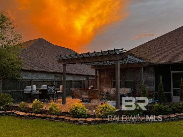 back house at dusk with a pergola, a patio, and an outdoor hangout area