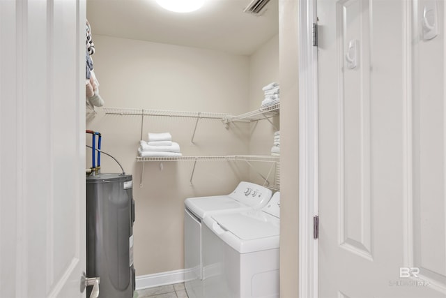 laundry area with separate washer and dryer, water heater, and light tile patterned floors