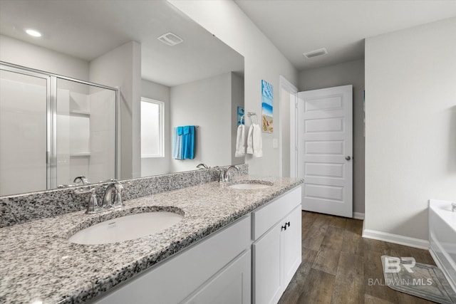 20567 Mercury Dr, Robertsdale, AL 36567 - full bathroom featuring wood finished floors, baseboards, a shower stall, double vanity, and a tub