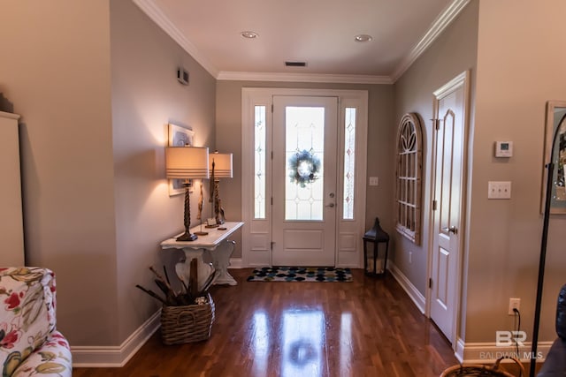 foyer featuring visible vents, wood finished floors, baseboards, and ornamental molding