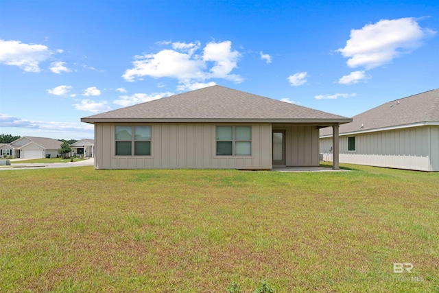 rear view of property featuring a lawn and a patio