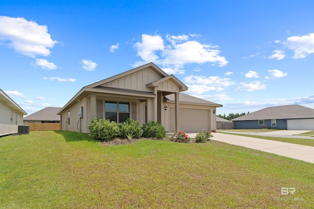 view of front of house with a garage, central AC, and a front yard