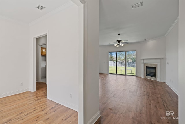 unfurnished living room featuring visible vents, wood finished floors, and crown molding